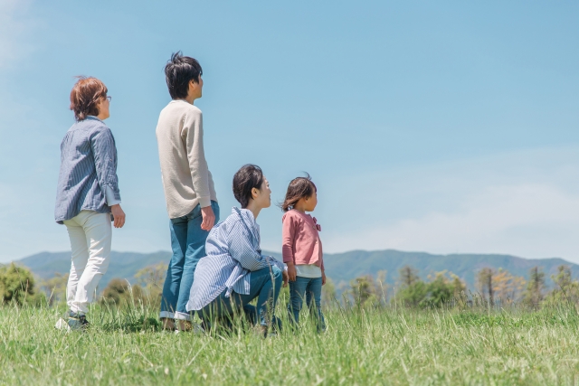 自然の中で空を見上げるアジア人家族